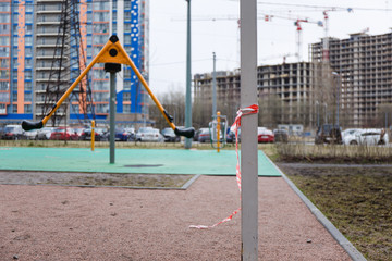 Children's playground in the city fenced with a signal red and white ribbon during the prom pandemic of coronavirus covid-19