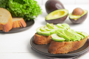 Homemade avocado on baked bread or sandwich with lettuce on plate bread on a wooden table. Cooking Health food 