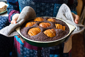 Woman hold chocolate baked apple, fruit and nuts brownie. Sweet vegan brown dessert cake, pie. Breakfast