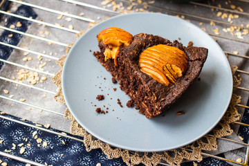 A piece of chocolate baked apple, fruit and nuts brownie. Sweet vegan brown dessert cake, pie. Breakfast
