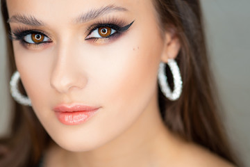 Portrait of a young beautiful brunette woman with bright eye makeup.