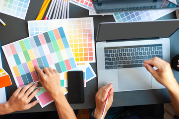 Professional designers are working on their desks at the office.