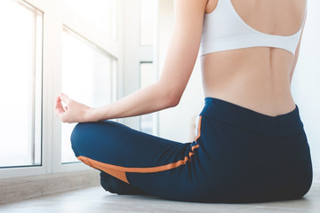 Close up of yoga woman sitting in lotus position at home on the terrace. a girl of European...