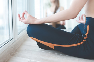 Close up of yoga woman sitting in lotus position at home on the terrace. a girl of European...