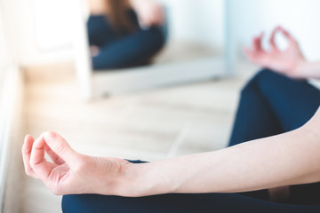 Close up of yoga woman sitting in lotus position at home on the terrace. a girl of European...