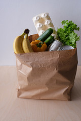 Donation paper bag with food: eggs, vegetables, fruits and canned food. Virus outbreak, coronavirus pandemic