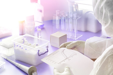 SARS-COV-2 pcr diagnostics kit. Epidemiologist in protective suit, mask and glasses mixes reaction to detect virus in patients samples. PCR detects 2019-nCoV virus causing Covid-19 pneumonia.