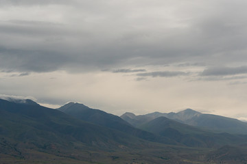 Fototapeta premium mountain valley under cloudy sky, rock ridge on horizon, hiking in mountains, rest and meditation in nature