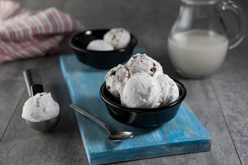 Dairy and stracciatella ice cream in black dessert bowls
