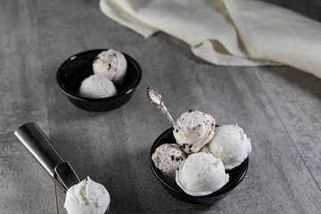 Dairy and stracciatella ice cream in black dessert bowls - Powered by Adobe