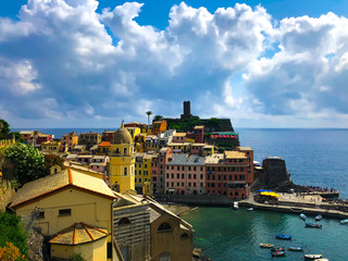 Gorgeous panoramic view of the bay in Vernazza. Landscape of Santa Margherita di Antiochia Church, the medieval Doria Castle and marina on a beautiful sunny day. Cinque Terre, Ligurian coast, Italy.