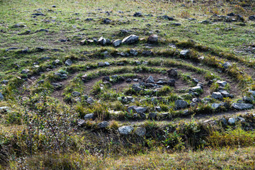 spiral of stones on green grass, symbol of ancient rites