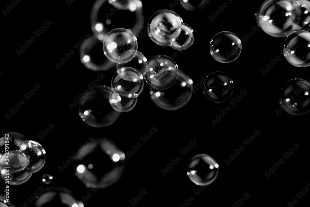 Wall mural transparent soap bubbles float on the dark, black background, bubbles abstract background,