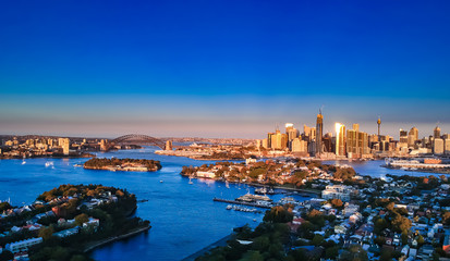 Panoramic drone aerial view over Sydney harbour on a cloudy sunset showing the nice colours of the harbour foreshore