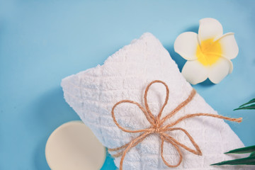 Fototapeta na wymiar Care, beauty and spa concept. Organic soap, white towel, plumeria frangipani flower. Copy space. Top view.