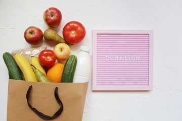 Paper bag with food supplies, vegetables and fruit. Healthy food and donation concept. Food...