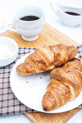Two homemade croissants with coffee on the table. Tea and pastries for breakfast.