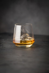 A glass of whiskey on a gray stone background