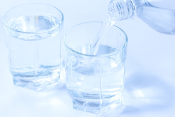 mineral water in a bottle and glasses close-up. background with water pouring from a bottle.