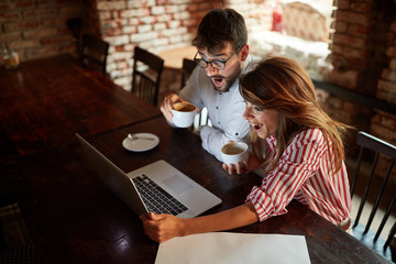 People sitting at a cafe,laughing together and enjoying at coffee.