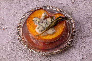 Grilled baked peach stuffed with blue cheese dorblu and rosemary. Top view