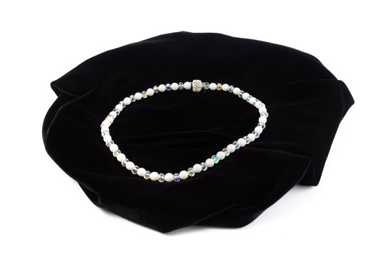 Natural Cacholong beads on black velvet. On a white background isolate