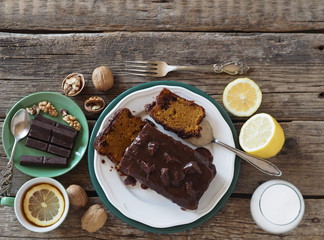 Festive homemade chocolate pumpkin long rectangular cupcake glazed with chocolate. Wooden table.