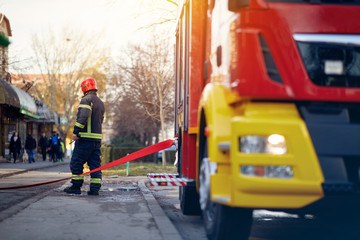  fireman connection a firehose to a connector device. Fireman at  work.