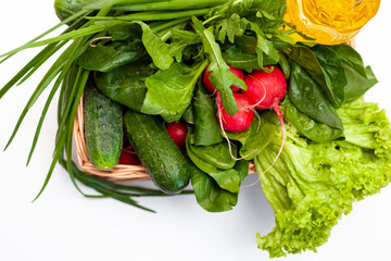 Delivery of products. Box with vegetables and sunflower oil. A set of greens for salad. Chives, lettuce, cucumbers, radishes, spinach, arugula. Isolated on a white background with place for text.