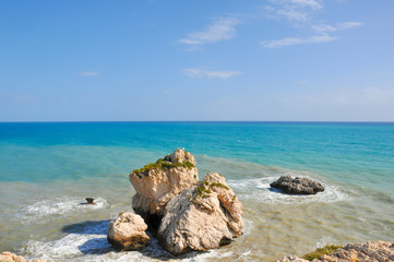 Fototapeta na wymiar Sunlit rocks in the azure sea water. The famous birthplace of beautiful Aphrodite.