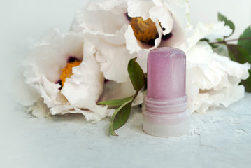 Natural cosmetic. Natural crystalline alum deodorant, against a background of peonies. Green...