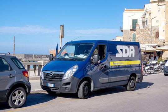 Blue Opel Movano EcoFlex post office van of the SDA Posta Italiane delivering the parcels and packages near the beach in Cefalu, Sicily