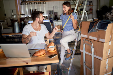 couple having fun and breakfast in coffee shop that they are about to open. starting business, joy, excitement, fun concept