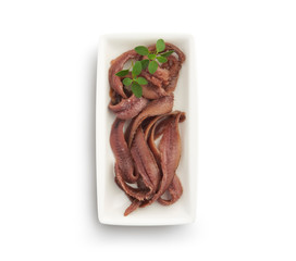 Anchovy fillets with herb, in a small dish isolated on white background, top view.