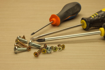 Hand screwdrivers and screws Several metal screws and  screwdrivers
