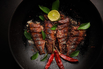 Frying pan with tasty trout fish on dark background