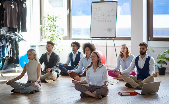 Business Colleagues Meditating At Work, Sitting On The Floor. Modern, Business, Meditation Concept