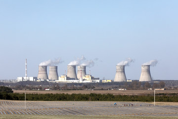 view of a nuclear power plant. View of smoking chimneys of nuclear power plant, power lines and...