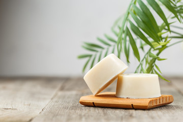 Eco friendly solid shampoo soap bar on wooden dish - obrazy, fototapety, plakaty