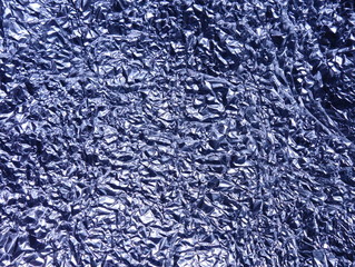 Crumpled aluminium foil background. Shiny faceted crinkled material.