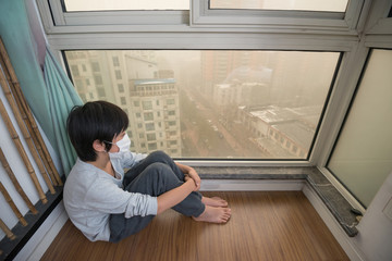 Young Asian boy wearing face mask at home to protect against air pollution