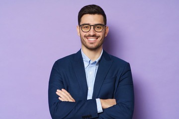Business male isolated on purple background, feeling energetic and confident, smiling happily,...