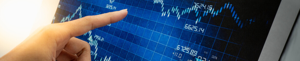 Hand pointing with blue graph stock using as background business investment money, financial, business growth cover page concept.