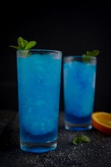 Frozen Blue Lagoon Cocktail against black background, selective focus