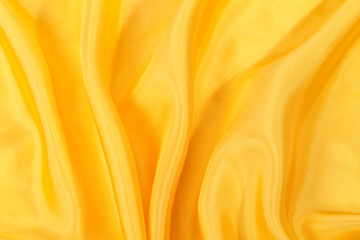 Silk background, texture of yellow shiny fabric