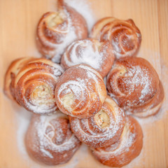 Pile of cheesecakes with caster sugar on a wooden round plate