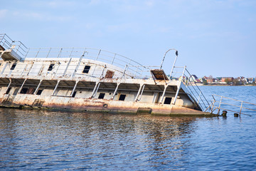 A sunken rusty ship half gone under the water of the sea, river, ocean.