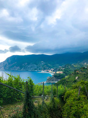 Fototapeta na wymiar Beautiful scenic view of Mediterranean turquoise sea and green mountains with vineyards visible from the hiking Cinque Terre trail from Vernazza to Monterosso al Mare in Italy.