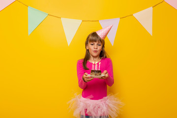 Birthday girl blowing candles on a cake