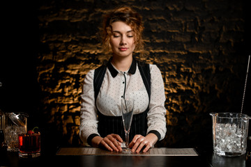 Young attractive girl bartender is standing at the bar.